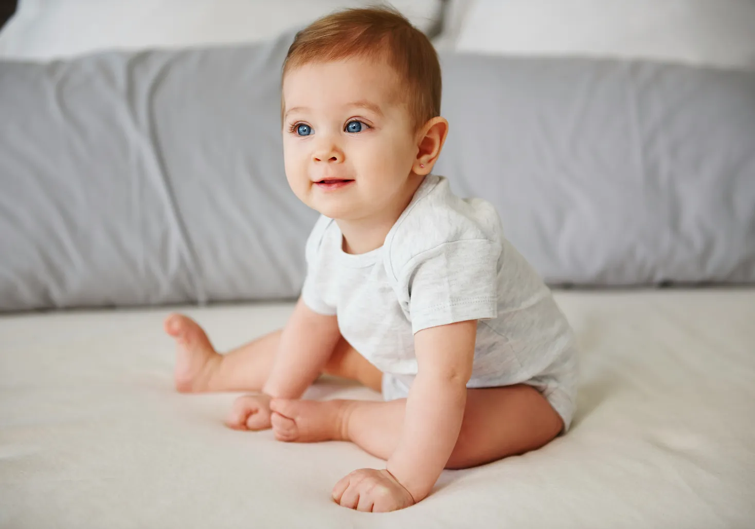 Smiling baby lying on a bed