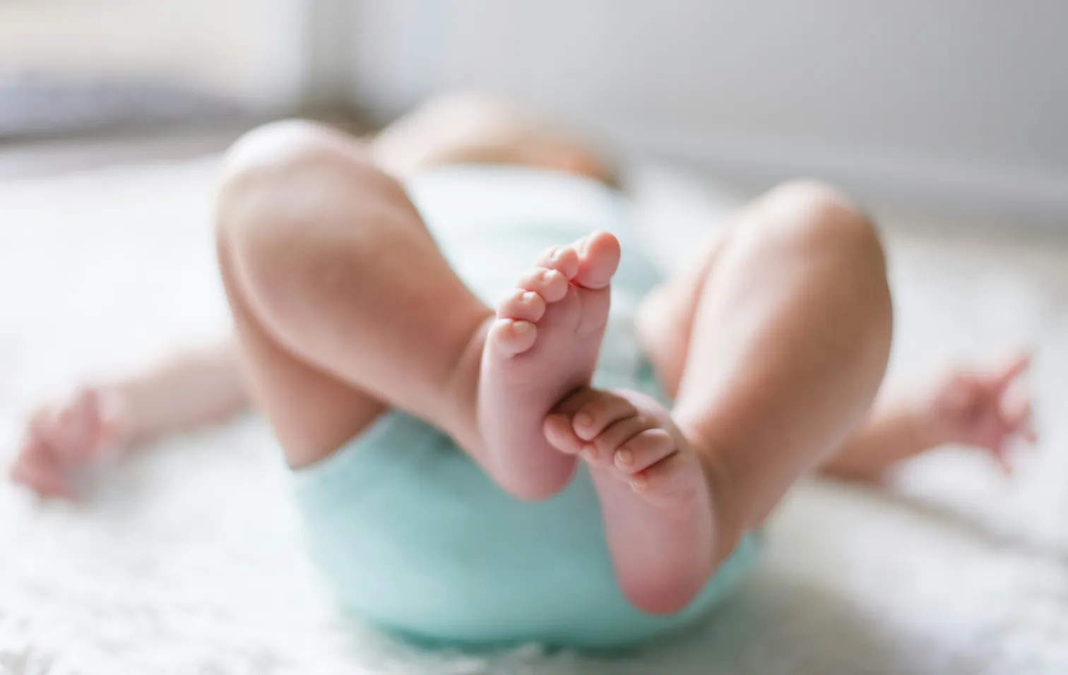 Newborn baby lying on a soft blanket