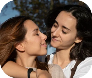 Two women holding their baby, foreheads close together