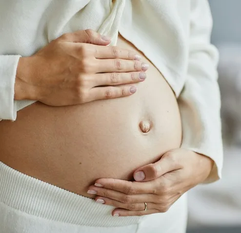 Hands resting gently on a pregnant belly