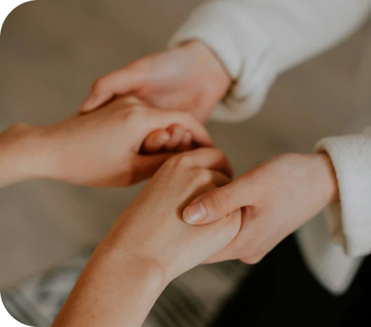 Two people holding hands in reassurance