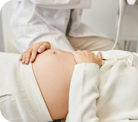 A doctor examining a pregnant woman's belly