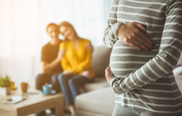 Future parents looking at surrogate expectant mother