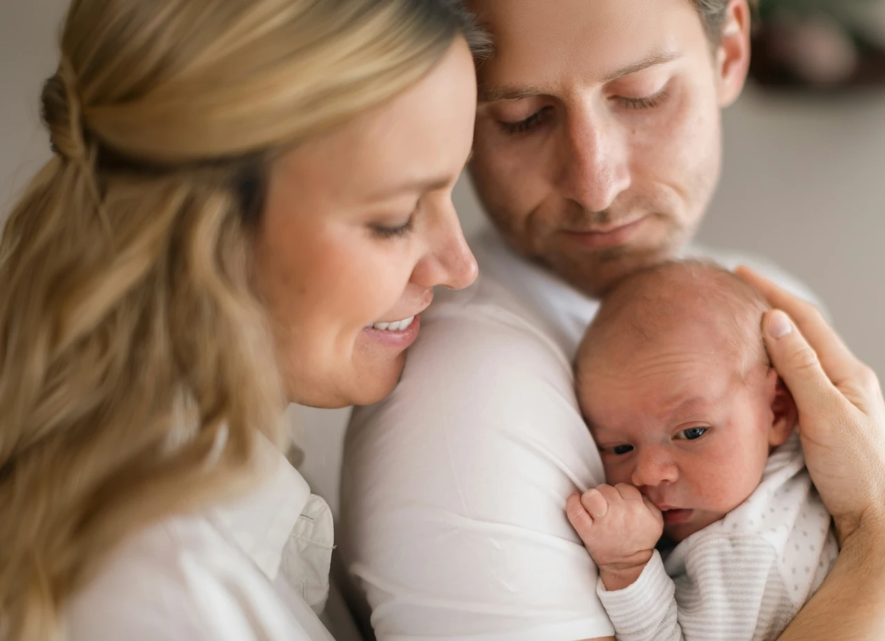 Newborn baby held by caring hands